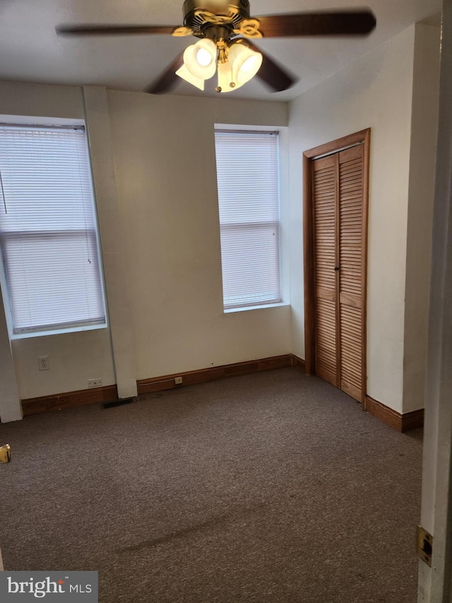 unfurnished bedroom with carpet flooring, ceiling fan, and a closet