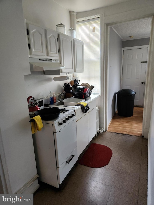 kitchen with white cabinets, sink, a textured ceiling, dark hardwood / wood-style flooring, and white range with gas cooktop