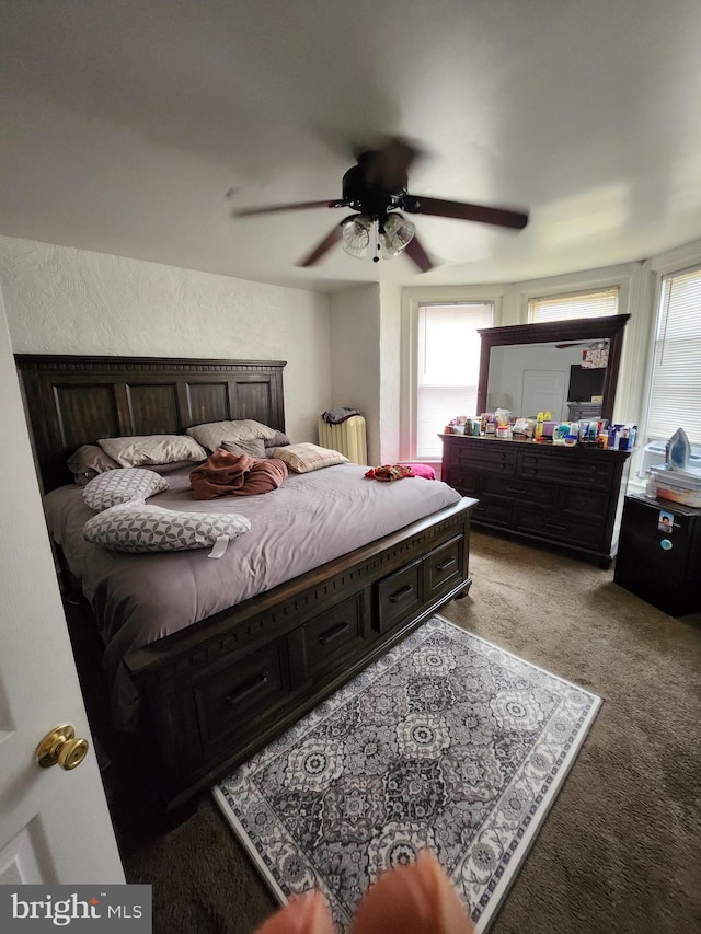 carpeted bedroom featuring multiple windows and ceiling fan