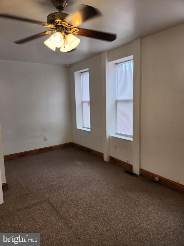 carpeted spare room featuring ceiling fan