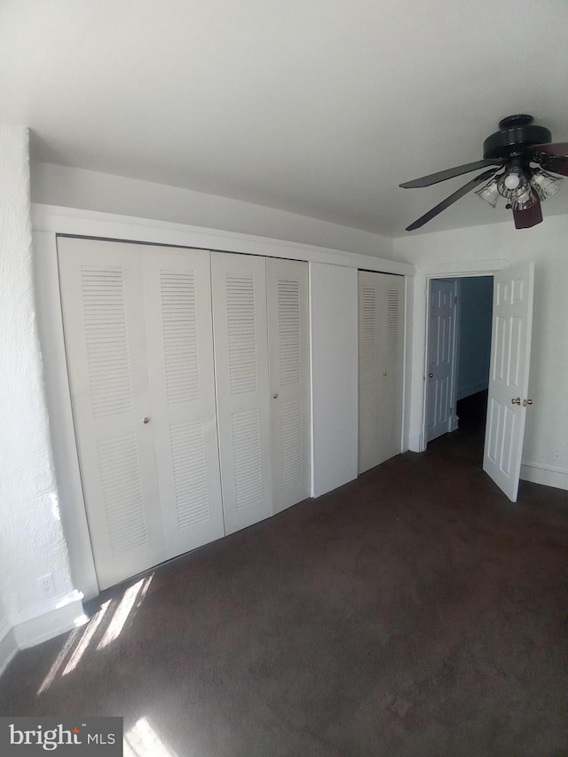 unfurnished bedroom featuring dark colored carpet and ceiling fan