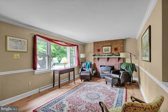 sitting room with a fireplace, baseboard heating, brick wall, ornamental molding, and hardwood / wood-style flooring