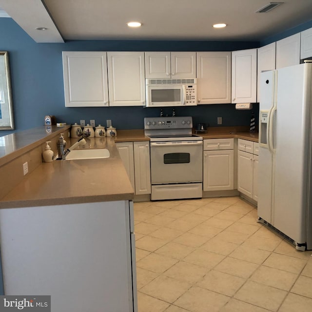 kitchen featuring white cabinetry, white appliances, kitchen peninsula, sink, and light tile floors