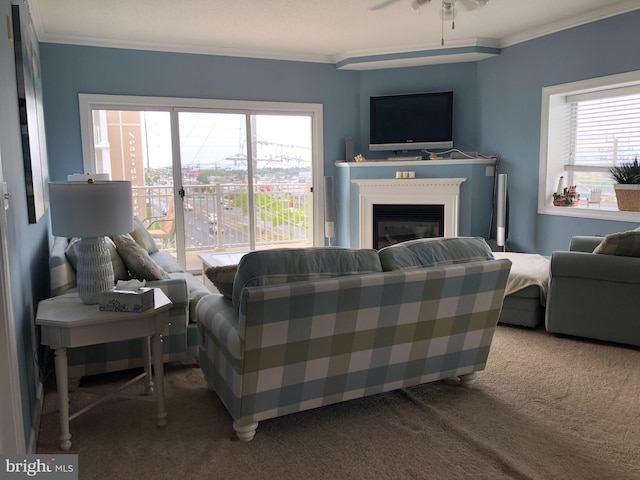 carpeted living room featuring crown molding and ceiling fan