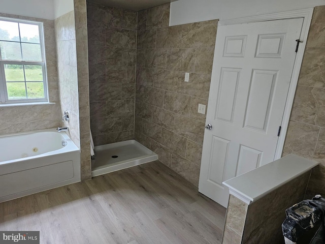 bathroom featuring tile walls, hardwood / wood-style flooring, and separate shower and tub