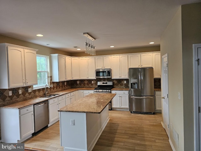 kitchen featuring stainless steel appliances, sink, a center island, and tasteful backsplash