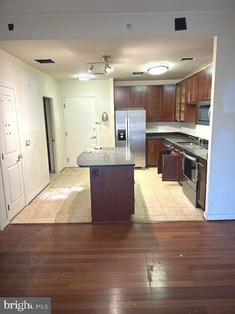 kitchen with a center island, sink, light wood-type flooring, and stainless steel appliances