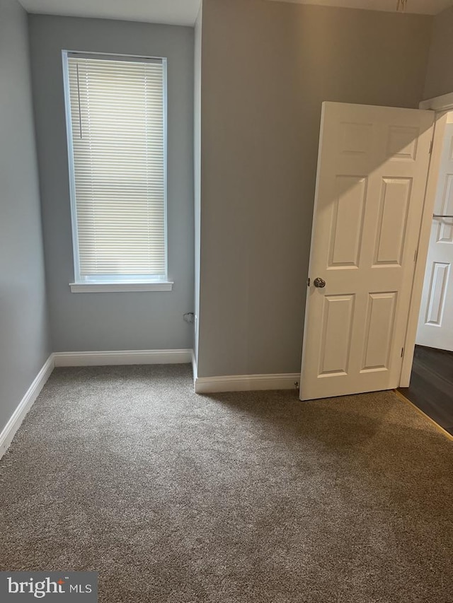 empty room featuring dark colored carpet