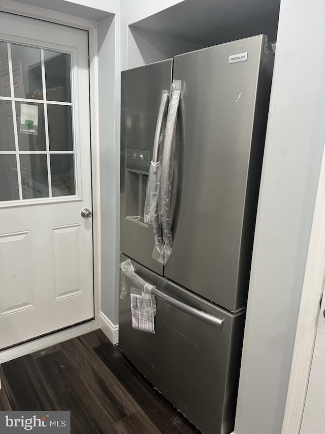 details featuring stainless steel refrigerator with ice dispenser and dark wood-type flooring