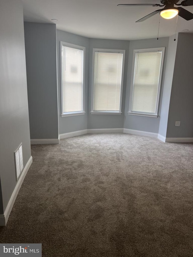 spare room featuring ceiling fan and carpet flooring