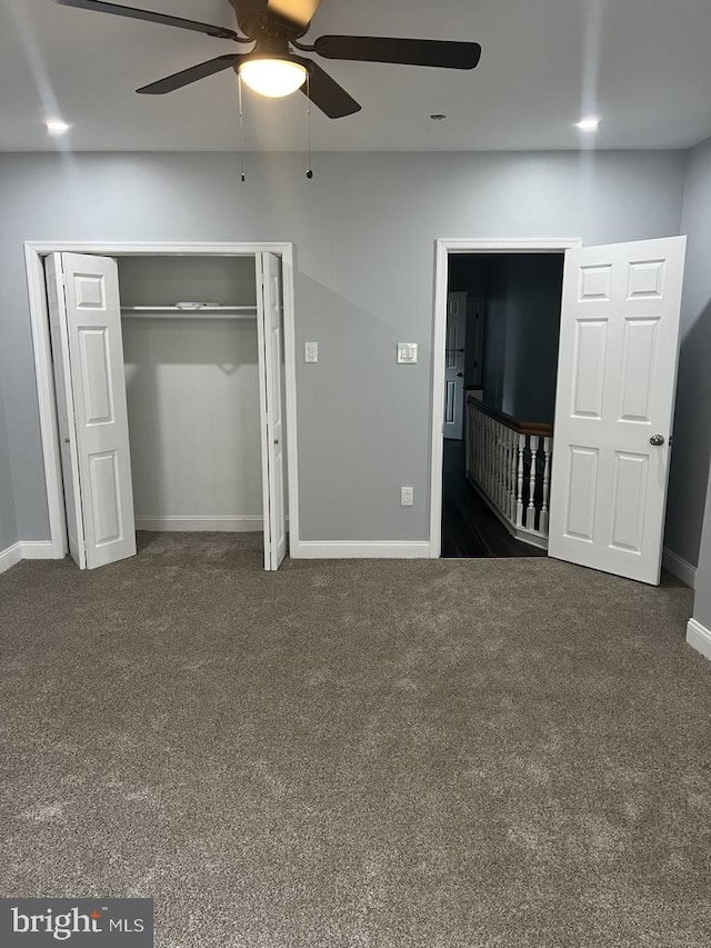 unfurnished bedroom with a closet, ceiling fan, and dark carpet