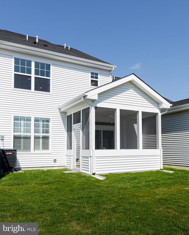 back of property featuring a sunroom and a yard