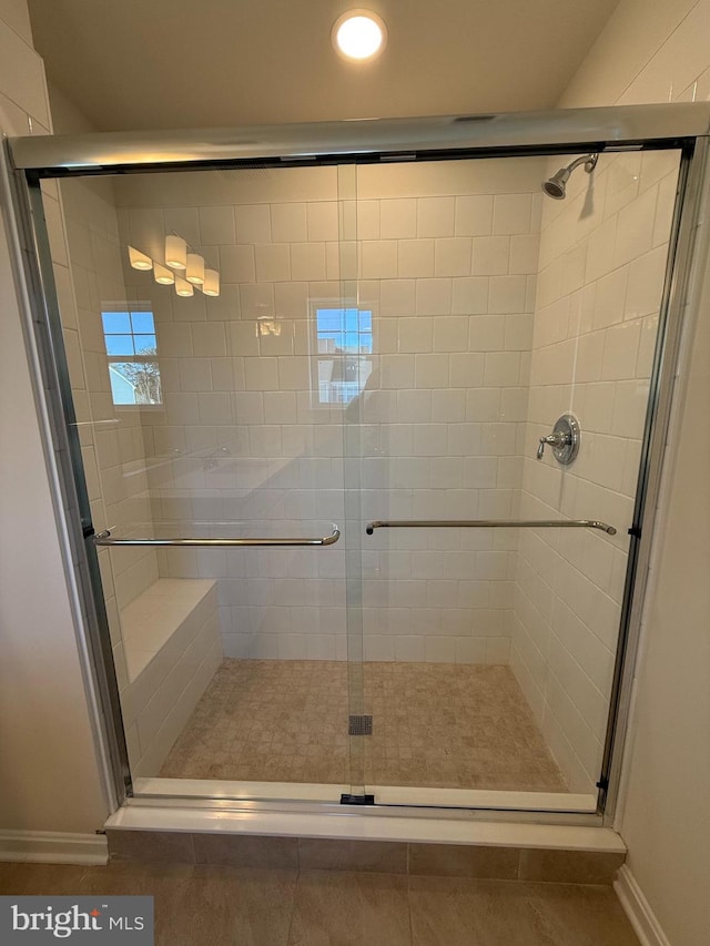 bathroom with a shower with shower door and tile patterned flooring