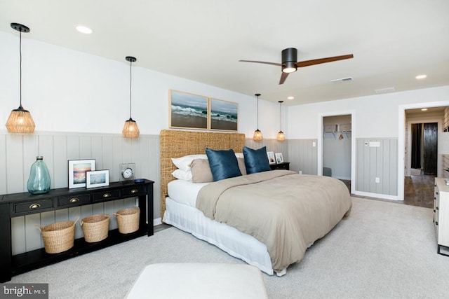 carpeted bedroom with a spacious closet, a closet, and ceiling fan