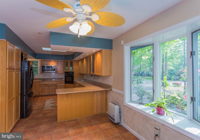 kitchen featuring ceiling fan, kitchen peninsula, black appliances, backsplash, and dark tile flooring