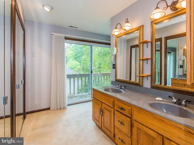 bathroom with a wealth of natural light, vanity with extensive cabinet space, and dual sinks