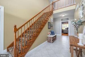 stairs with tile floors and a high ceiling