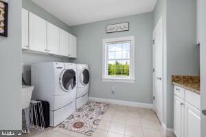 laundry room featuring cabinets, independent washer and dryer, and light tile floors