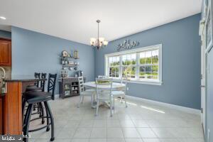 dining room featuring light tile floors and an inviting chandelier