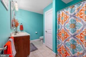 bathroom with tile floors, vanity, and toilet