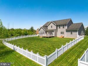 back of property with a lawn and a deck