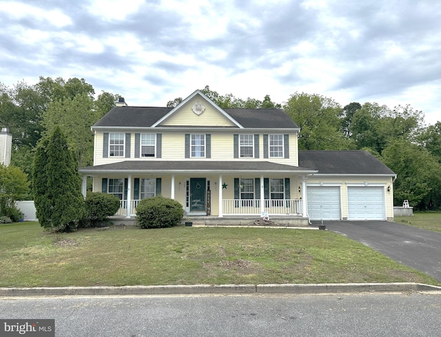 colonial house featuring a garage, a front yard, and a porch