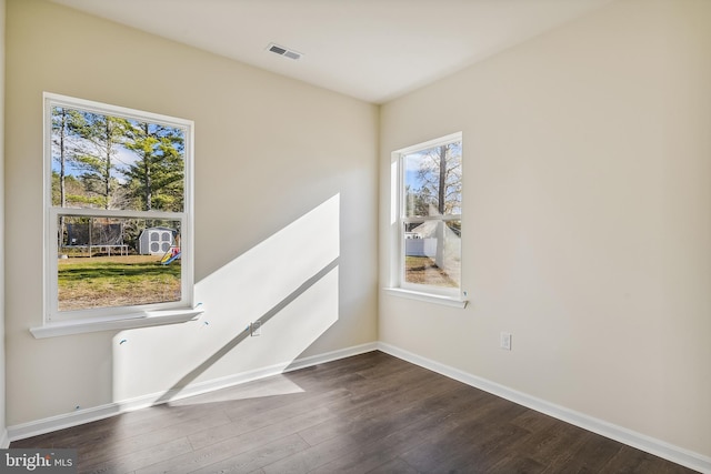 empty room with dark hardwood / wood-style flooring