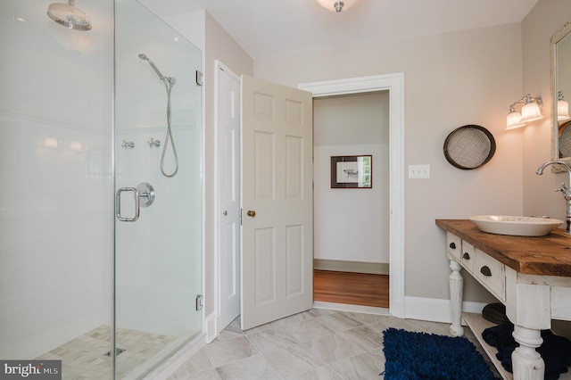 bathroom featuring a shower with shower door, vanity, and tile floors