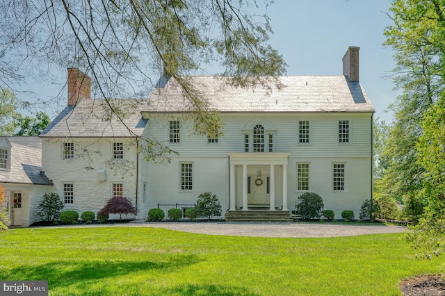 colonial home featuring a front yard