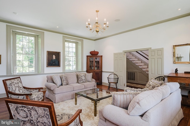 living room featuring dark wood-type flooring, a chandelier, and crown molding