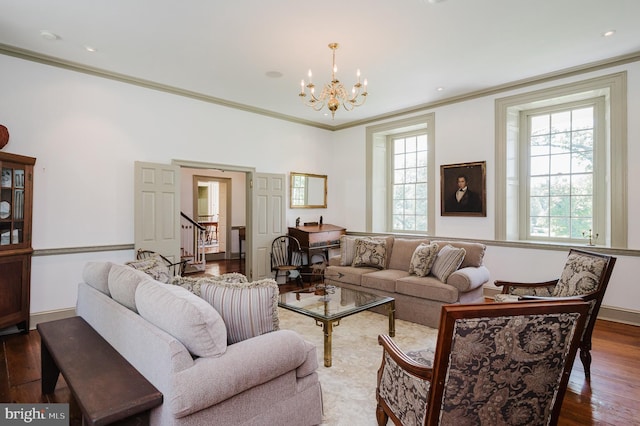 living room with an inviting chandelier, hardwood / wood-style flooring, and crown molding