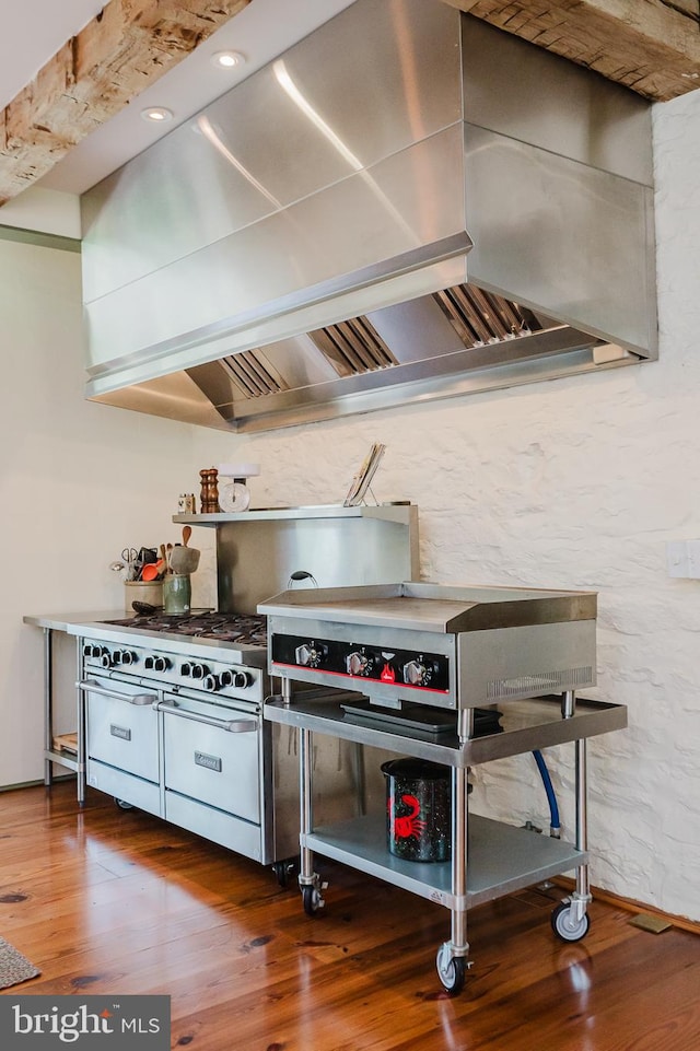 kitchen with wall chimney exhaust hood and hardwood / wood-style floors