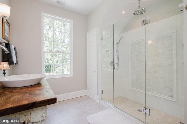 bathroom with tile floors, an enclosed shower, and a wealth of natural light