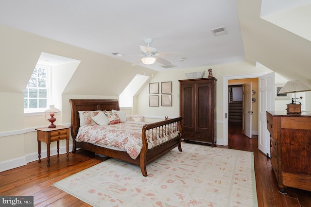 bedroom with ceiling fan, vaulted ceiling, and wood-type flooring