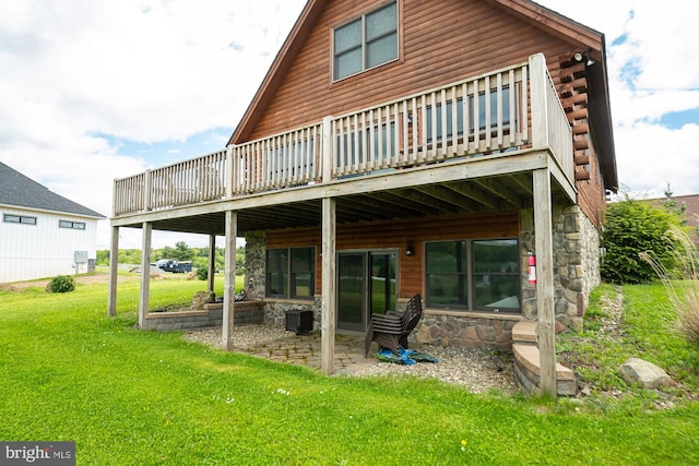 back of house featuring stone siding, a deck, a patio, and a yard