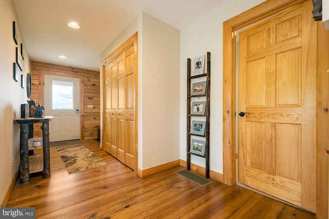 foyer featuring wooden walls and wood-type flooring