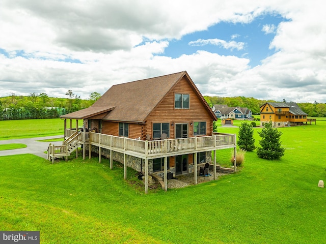 rear view of house featuring a lawn and a deck