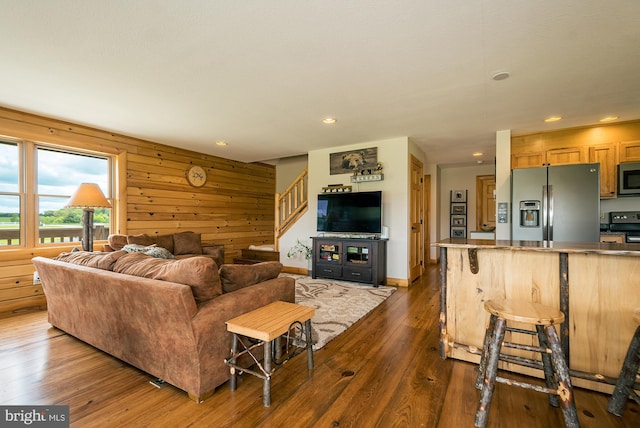 living room with wood walls, stairway, wood-type flooring, and recessed lighting