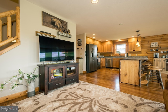 interior space with wood walls, dark hardwood / wood-style floors, and sink