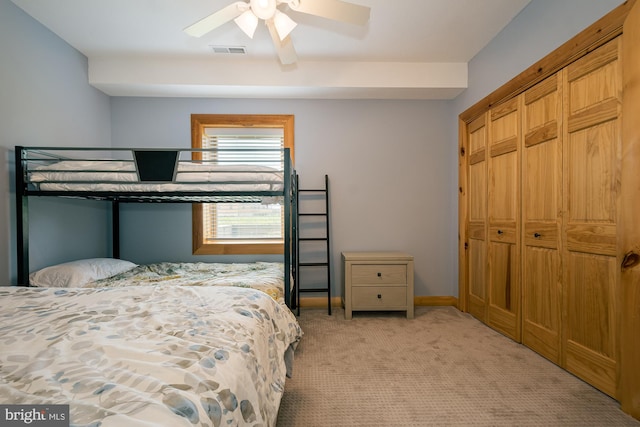 bedroom with light colored carpet, a ceiling fan, baseboards, visible vents, and a closet