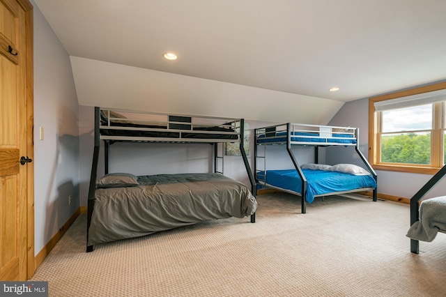 carpeted bedroom with lofted ceiling