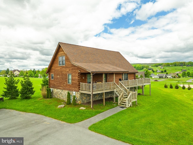 log home with stairs, log siding, a porch, and a lawn