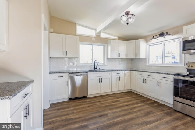 kitchen featuring stainless steel appliances, vaulted ceiling with beams, white cabinetry, dark wood-type flooring, and sink