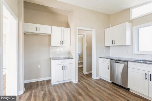 kitchen featuring light stone countertops, dishwasher, backsplash, and dark wood-type flooring