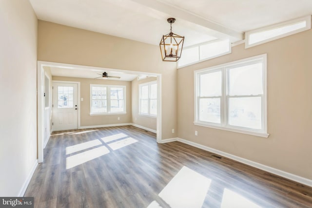 spare room featuring dark hardwood / wood-style floors and ceiling fan with notable chandelier