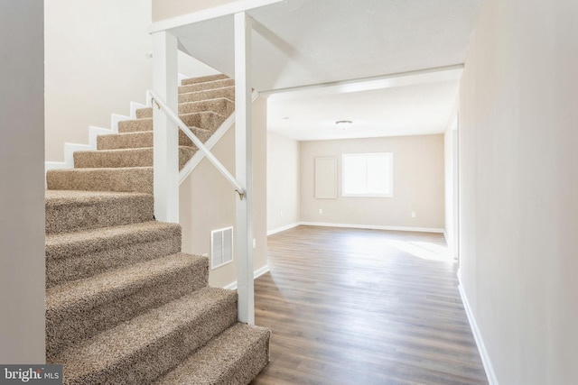 staircase featuring dark wood-type flooring