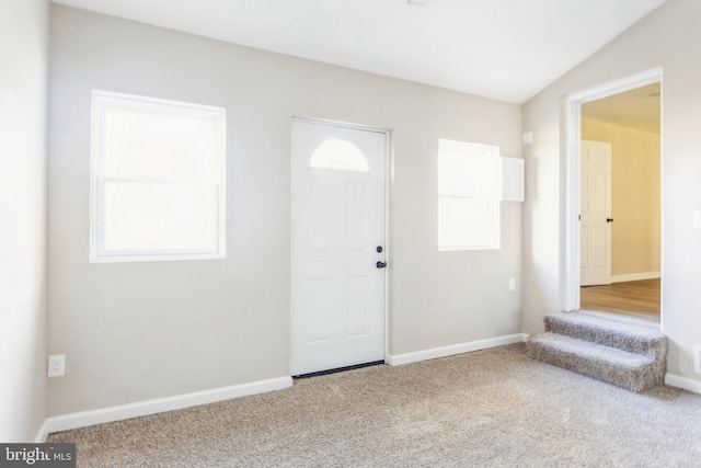 foyer with carpet flooring and vaulted ceiling