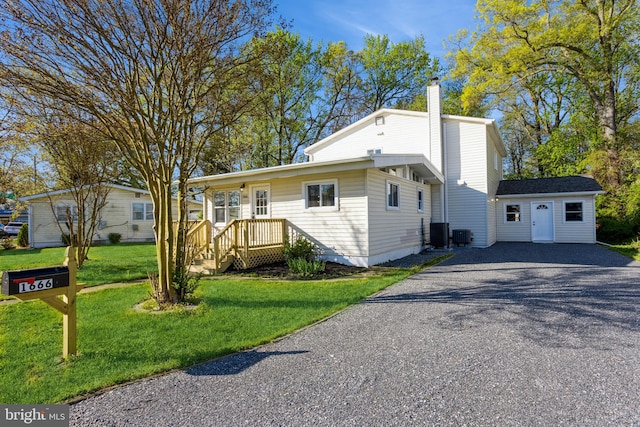 view of front of home featuring a front lawn and a storage shed