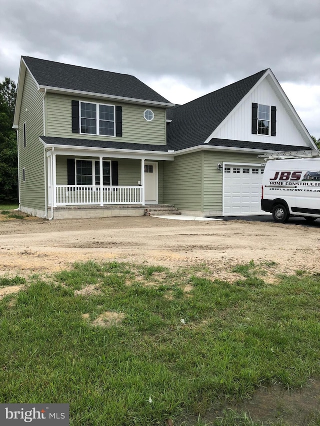 view of front of home with a porch, a garage, and a front lawn