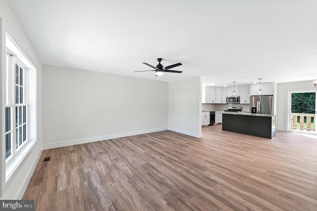 unfurnished living room featuring light hardwood / wood-style floors and ceiling fan